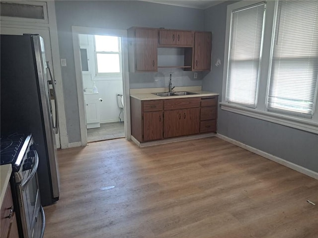 kitchen featuring sink, stainless steel gas range, and light wood-type flooring