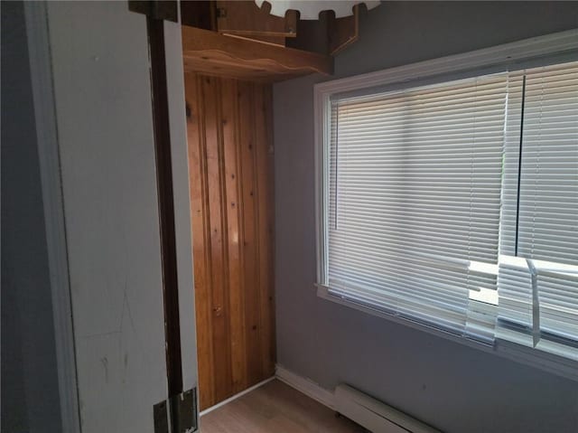 interior space featuring a baseboard heating unit and light hardwood / wood-style floors