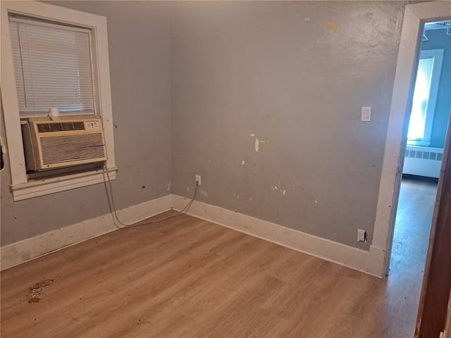 spare room with light hardwood / wood-style floors, cooling unit, and radiator heating unit