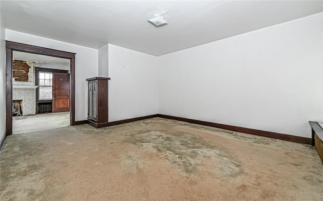 spare room featuring carpet flooring and a fireplace