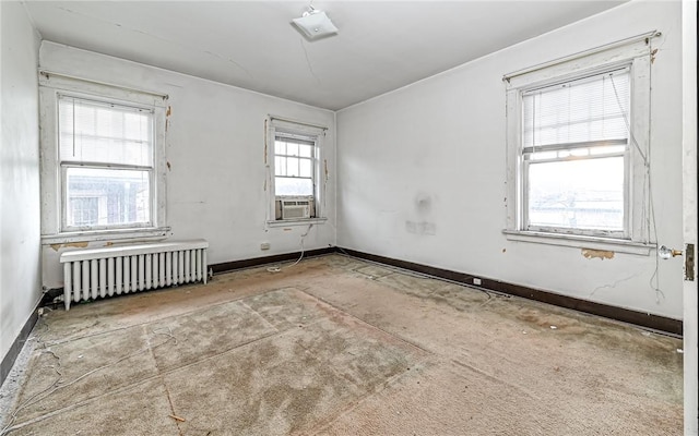 unfurnished room featuring radiator, plenty of natural light, and cooling unit