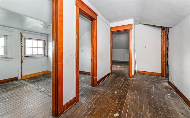 hallway with dark hardwood / wood-style floors and vaulted ceiling