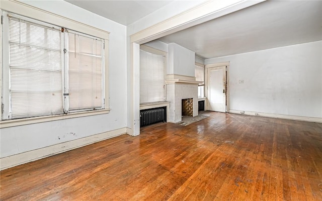 unfurnished living room featuring hardwood / wood-style flooring and radiator