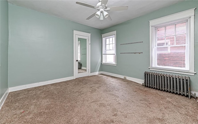 carpeted spare room featuring ceiling fan and radiator heating unit