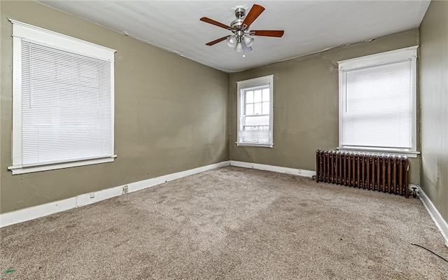 unfurnished room featuring ceiling fan, radiator heating unit, and light carpet