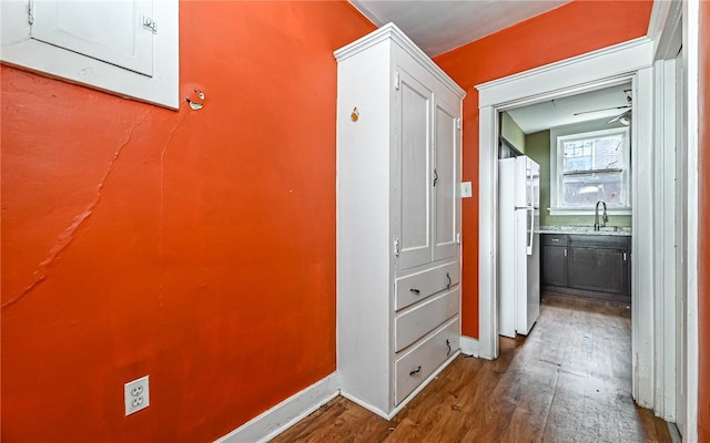 corridor with electric panel, hardwood / wood-style floors, and sink