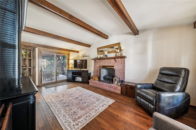 living room with dark wood-type flooring, beamed ceiling, and a brick fireplace