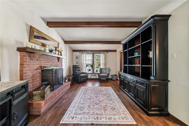 living room featuring dark hardwood / wood-style flooring, beamed ceiling, and a brick fireplace