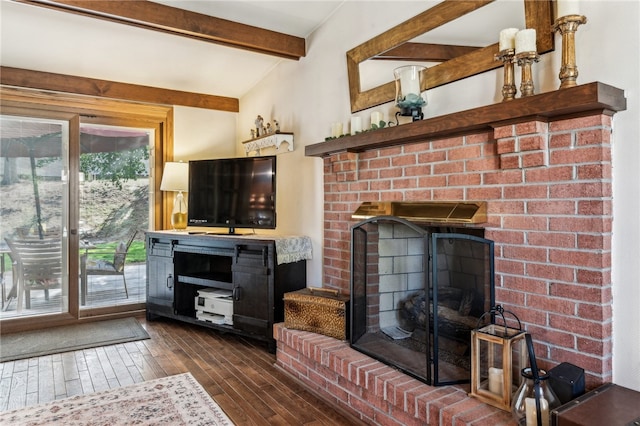 living room with dark wood-type flooring, lofted ceiling with beams, and a brick fireplace