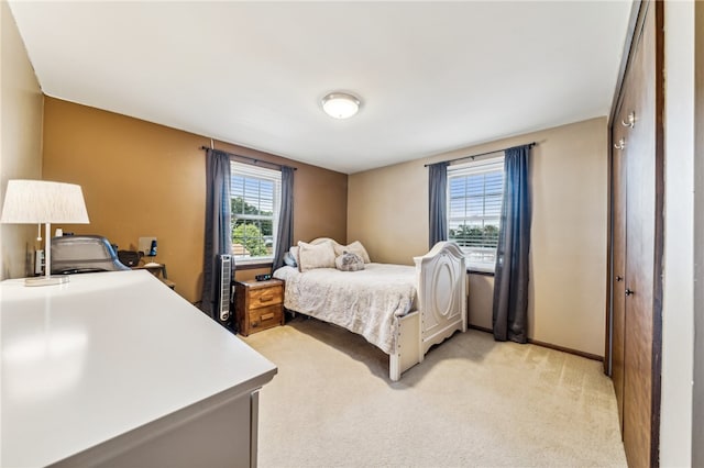 bedroom featuring light carpet and a closet