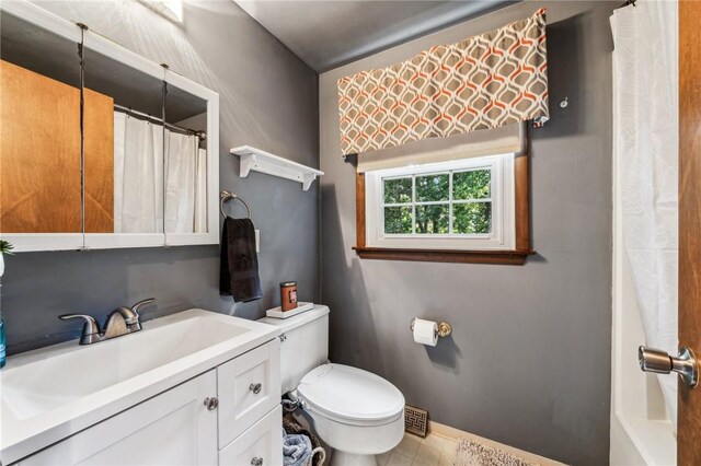 bathroom featuring vanity, curtained shower, and toilet