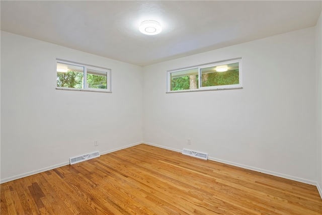 unfurnished room with plenty of natural light and light hardwood / wood-style floors