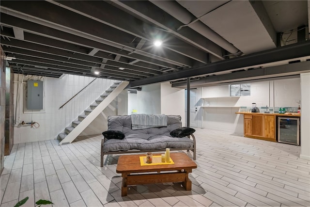 basement featuring light wood-type flooring, wine cooler, and electric panel