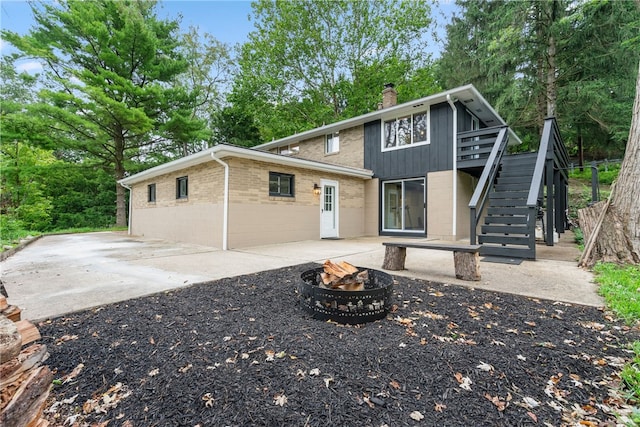 view of front property featuring a wooden deck, a fire pit, and a patio area