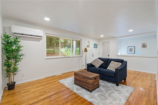 living room featuring a wall mounted AC and light wood-type flooring