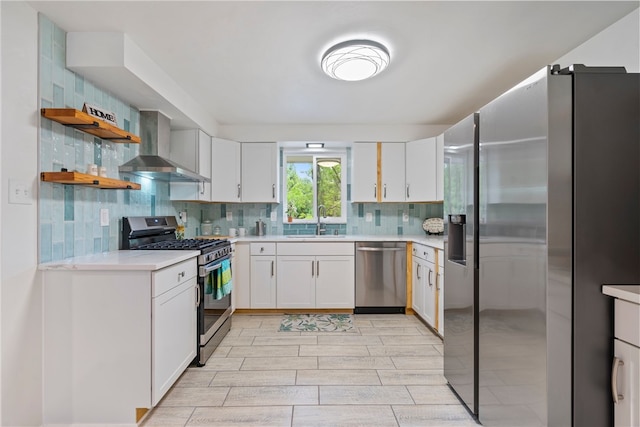 kitchen with wall chimney range hood, tasteful backsplash, sink, light tile patterned flooring, and stainless steel appliances