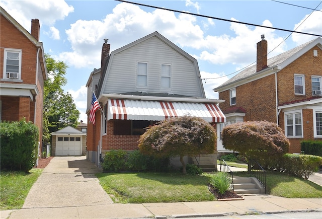 view of front facade featuring a front lawn, a garage, and an outdoor structure