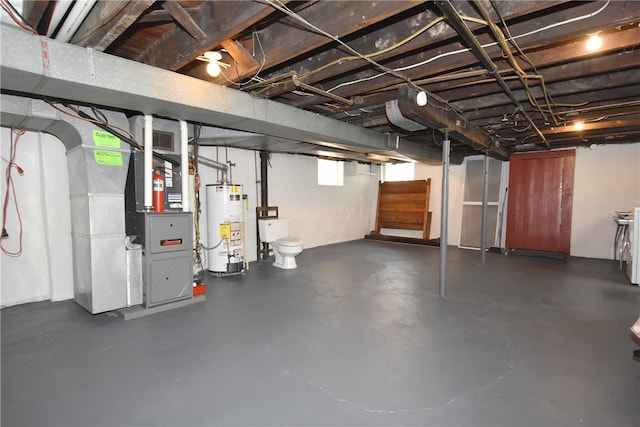 basement featuring water heater, heating unit, and a wealth of natural light