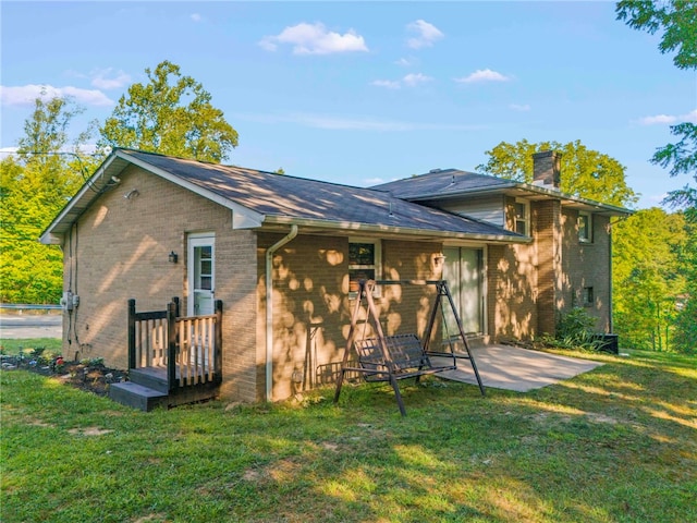 rear view of property with a patio and a yard