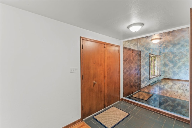 entrance foyer with a textured ceiling and tile patterned floors