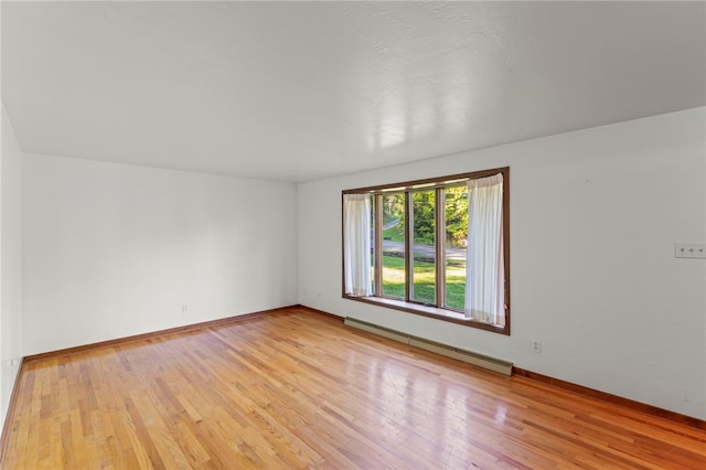 unfurnished room featuring light hardwood / wood-style floors and baseboard heating