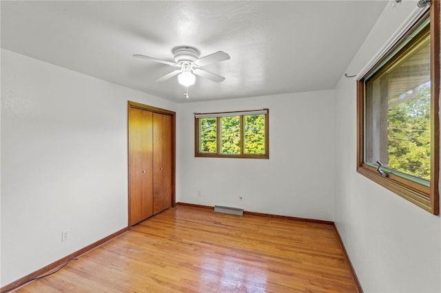 empty room featuring ceiling fan, plenty of natural light, and light hardwood / wood-style floors