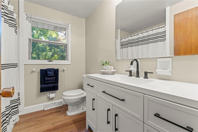 bathroom with hardwood / wood-style flooring, vanity, and toilet