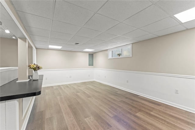 basement with a paneled ceiling and hardwood / wood-style flooring