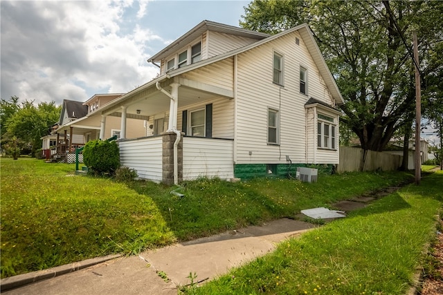 view of side of property with a lawn and central AC unit