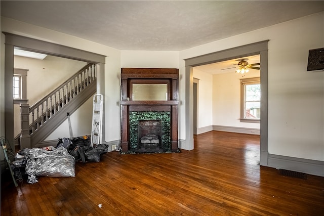 living room featuring ceiling fan, a fireplace, and hardwood / wood-style flooring