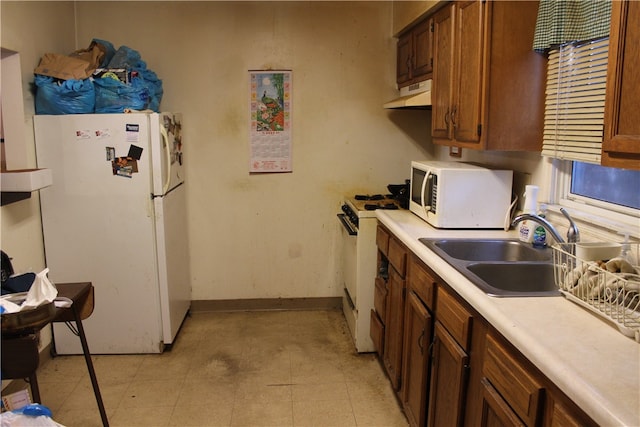 kitchen with white appliances, sink, and light tile patterned flooring