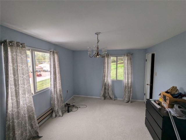 carpeted empty room with baseboard heating, plenty of natural light, and a notable chandelier