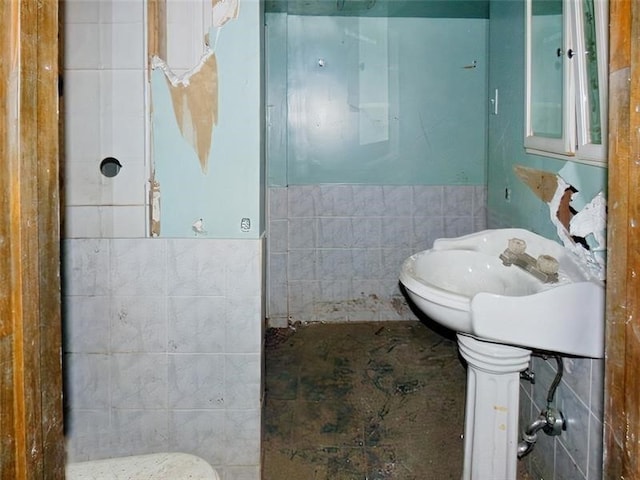 bathroom featuring tile walls and toilet