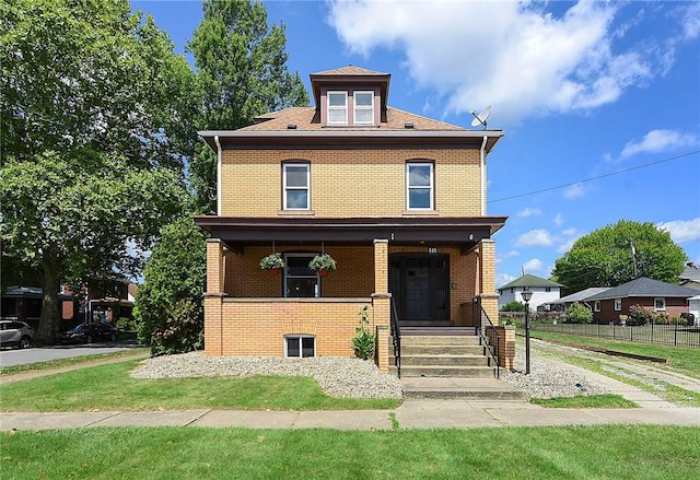 traditional style home featuring covered porch, fence, and brick siding