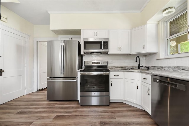 kitchen featuring appliances with stainless steel finishes, dark wood-type flooring, a sink, and white cabinetry