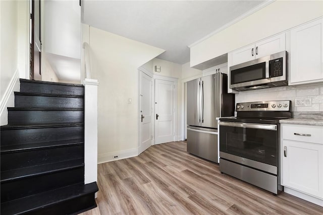 kitchen with stainless steel appliances, light wood-style floors, white cabinets, light countertops, and decorative backsplash