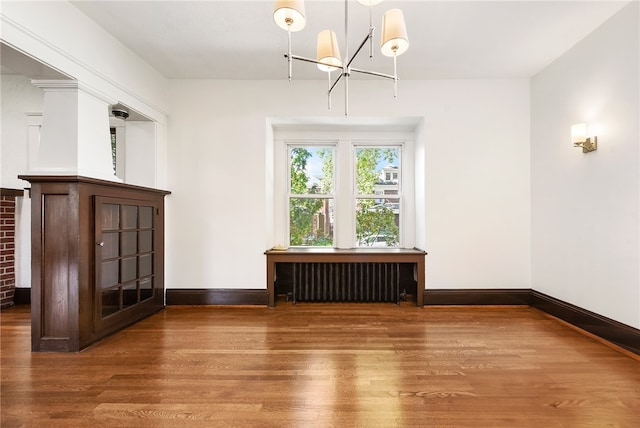 interior space featuring radiator heating unit and hardwood / wood-style floors