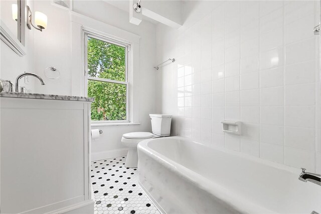 bathroom featuring a healthy amount of sunlight, toilet, and tile patterned flooring