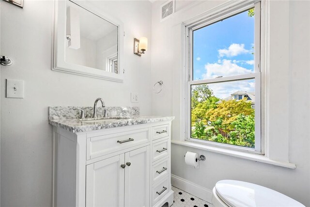 bathroom with vanity, toilet, plenty of natural light, and tile patterned flooring