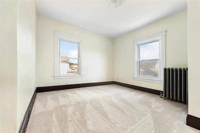 carpeted empty room featuring baseboards, radiator heating unit, and a healthy amount of sunlight