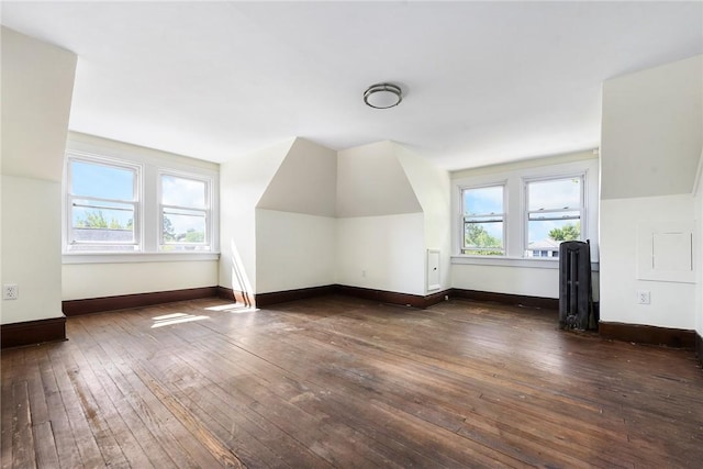 additional living space with dark wood-style floors and baseboards