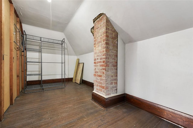 bonus room with vaulted ceiling, dark wood-type flooring, and baseboards