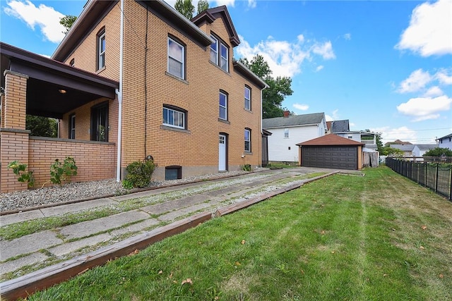 view of home's exterior with brick siding, fence, a detached garage, and a lawn