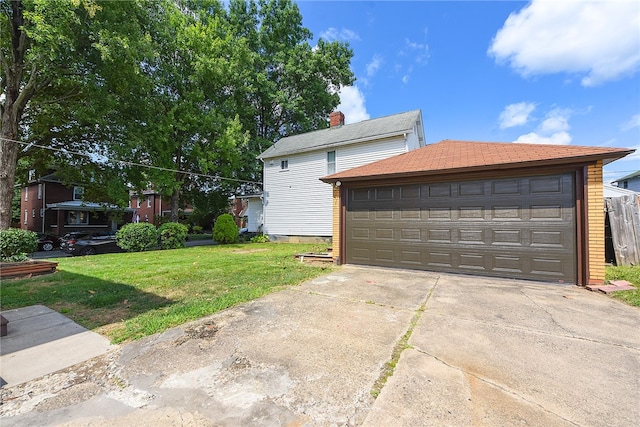 view of front of property featuring an outdoor structure, a front yard, and a garage