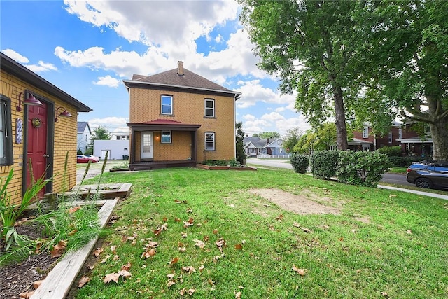 back of property with brick siding and a lawn