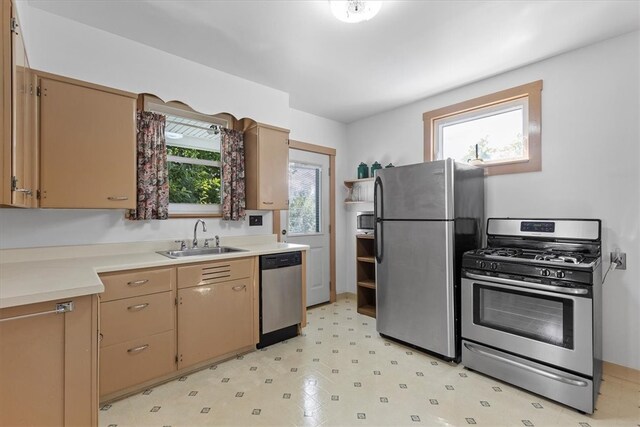 kitchen featuring light tile patterned flooring, stainless steel appliances, sink, and a healthy amount of sunlight