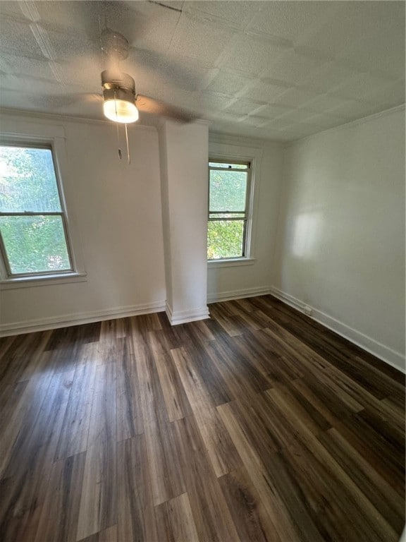 unfurnished room featuring dark wood-type flooring and ceiling fan