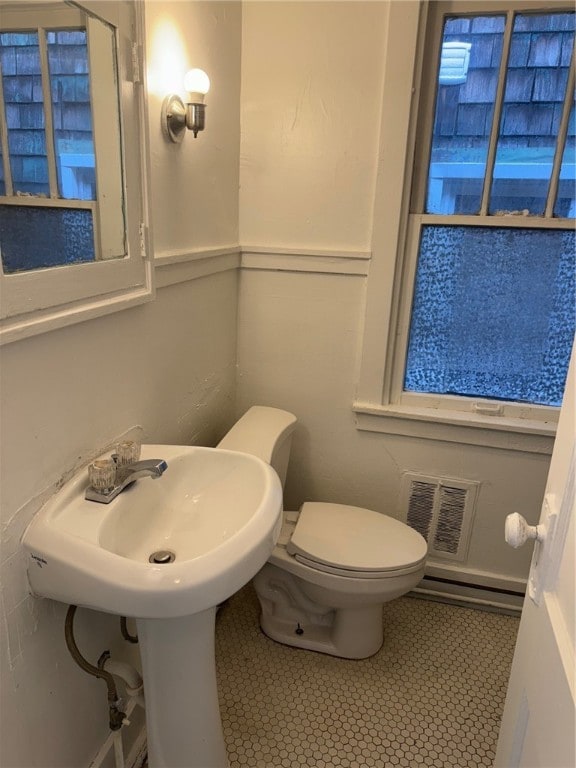 bathroom featuring tile patterned flooring, toilet, and baseboard heating