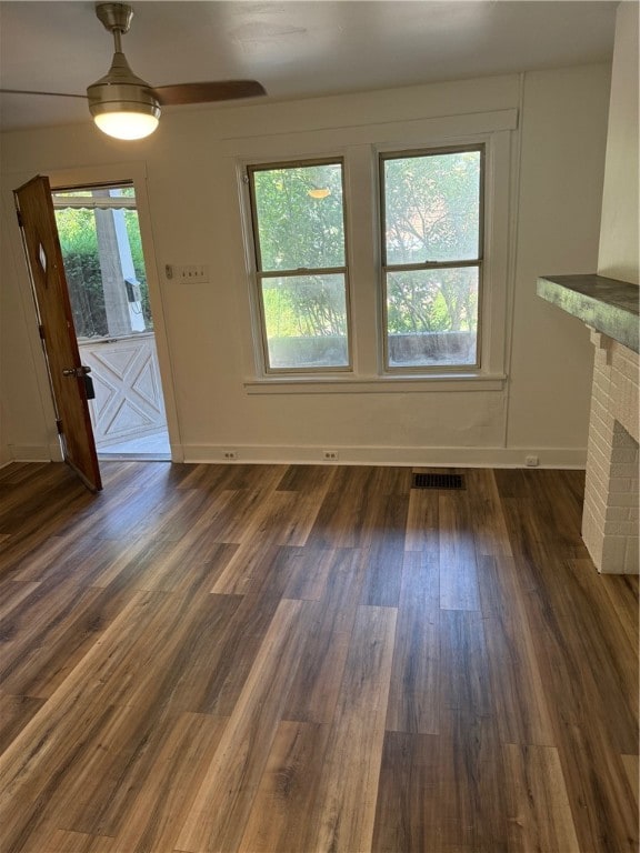 unfurnished living room featuring dark wood-type flooring and a fireplace