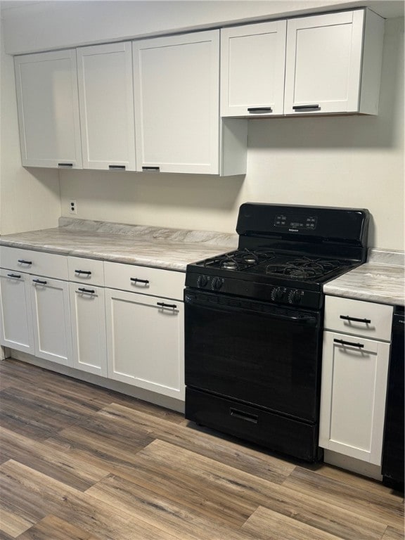 kitchen featuring white cabinetry, black appliances, and light wood-type flooring